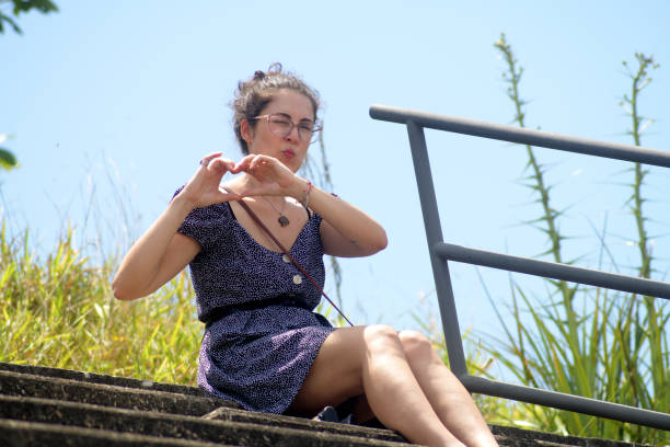 Young woman in the stands making heart