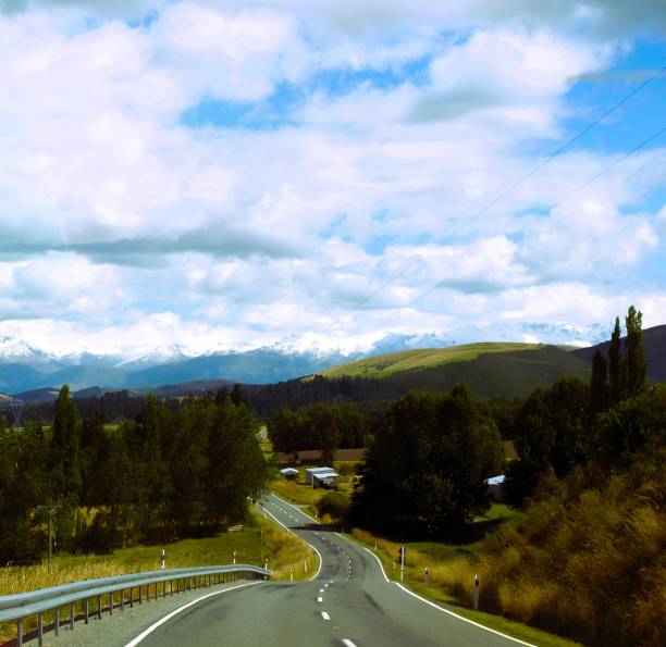 istock Scenic Road through Lush Greenery and Snow-Capped Mountains 2178422412