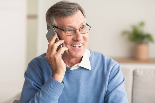 istock Elderly Man Talking On Cellphone Sitting On Couch At Home 2178424187