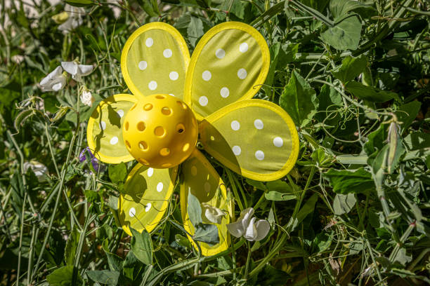 Yellow Pickleball flower with leafy background.