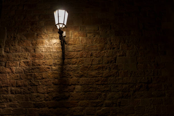 istock An atmospheric and delicately glowing lamp, illuminating a brick wall. 2178431319