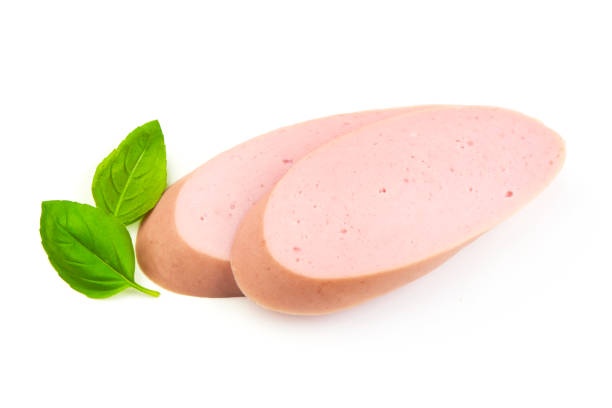 Fresh Boiled sausage slices with basil leaves, isolated on white background.