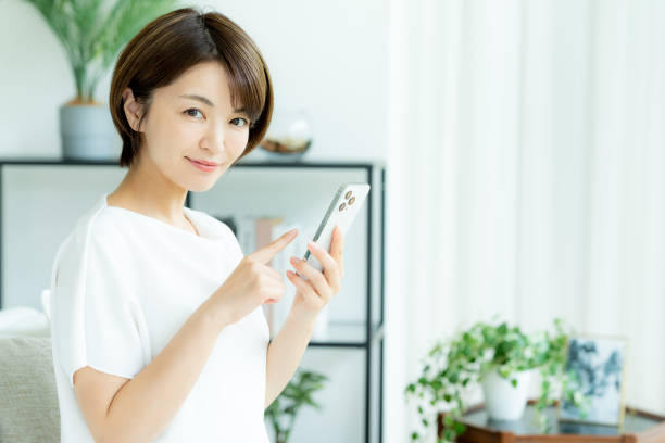 istock Middle-aged woman operating a smartphone in the room 2178434370
