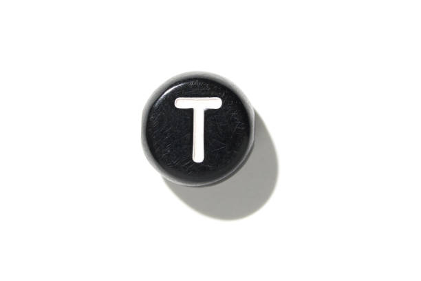 Vintage black keyboard key with letter t on white background, minimalist design, typing concept, high contrast shadow play