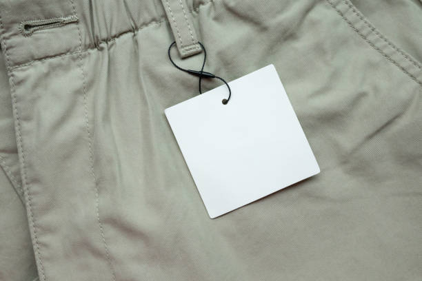 Blank white clothes tag label on gray fabric texture background