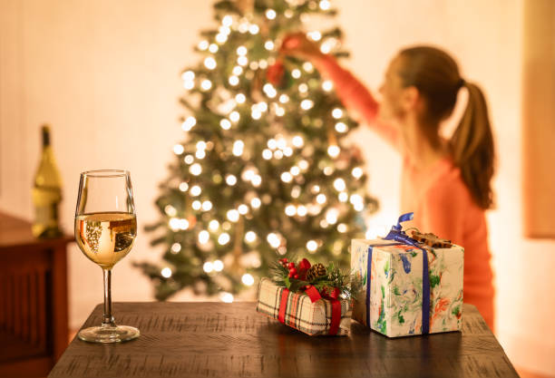 Young woman decorating Christmas tree.