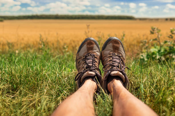 Point view of unrecognizable man and woman, and their hiking boots while traveling and exploring nature
