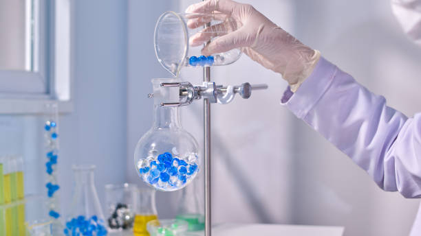 istock Blue and transaprent hydrogel poured into boiling flask in metal stand in modern laboratory background. Creative template photo for promotional 2178456255