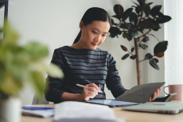 istock Asian woman enjoying with work using tablet sitting at office. 2178457564