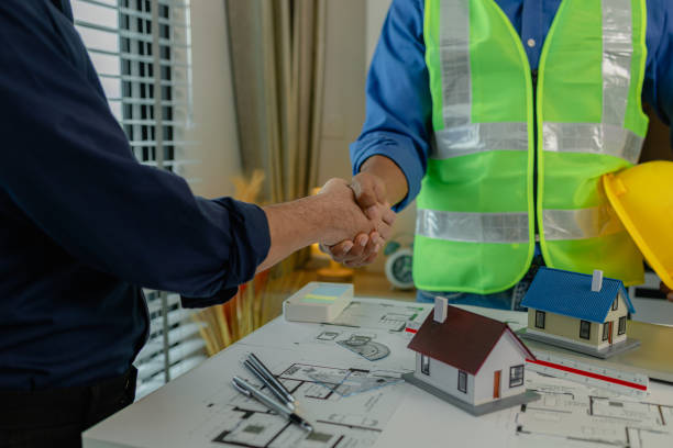 istock engineer and architect are shaking hands to celebrate because they just finished big construction project, two engineers do handshake after the meeting, blueprint is on the desk 2178458316