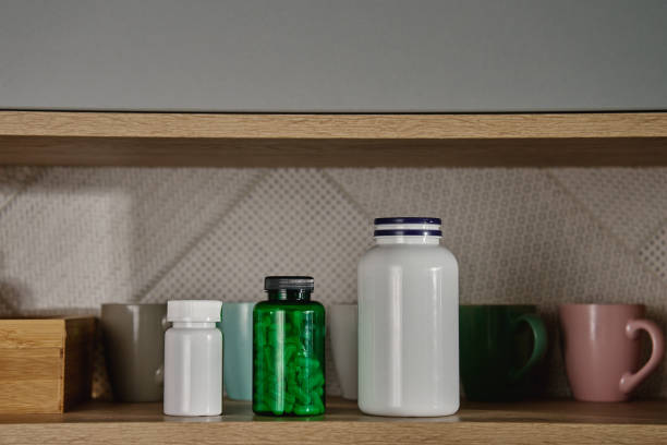 istock Kitchen shelf with mugs and medical containers with pills and vitamins 2178461572
