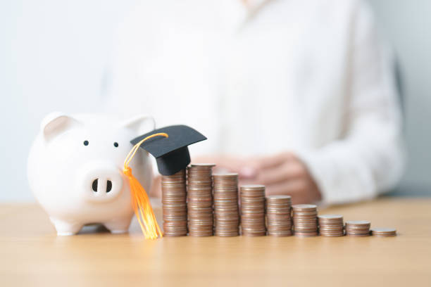 istock Money saving for Education, Scholarship, Student loan and debt and study future plan concept. Coins stack growing up with piggy and graduation hat on table 2178463753