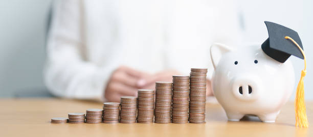 istock Money saving for Education, Scholarship, Student loan and debt and study future plan concept. Coins stack growing up with piggy and graduation hat on table 2178463760