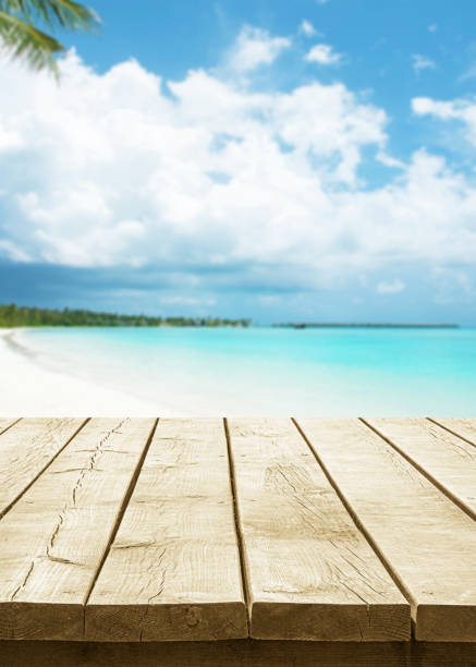 Empty wooden table top with beautiful tropical paradise beach background