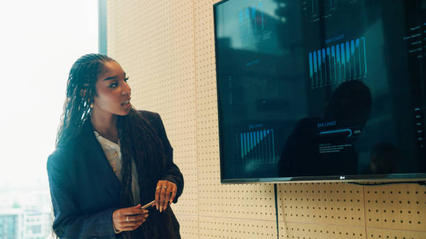 istock Young Afro-Asian woman making a project presentation and using visual aids for teammates to understand easily. 2178469151