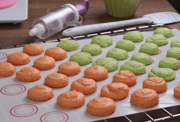 istock Macarons halves on baking mat on kitchen table. Dessert made at home. 2178470130