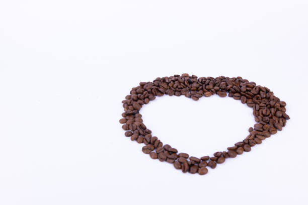 Heart made out of coffee beans on a white background