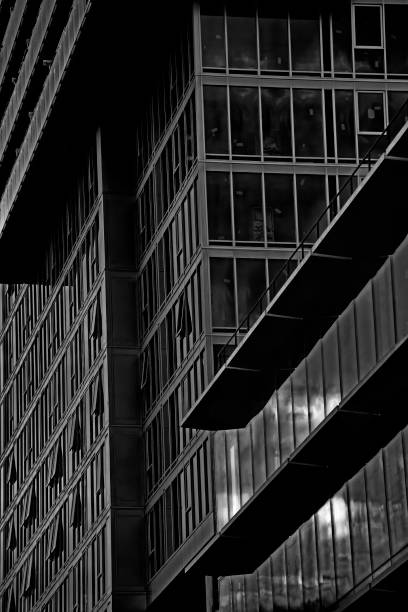 istock Black and white abstract image of modern architecture with reflection of clouds in glass facade emphasizing pattern, lines, design, pattern. 2178474683