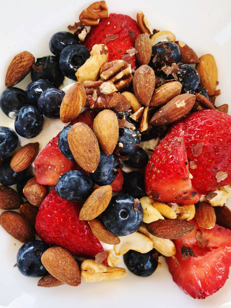 A delicious bowl of creamy Greek yogurt topped with fresh strawberries, plump blueberries, and crunchy almonds. This vibrant and nutritious dish is perfect for breakfast or a refreshing snack, combining creamy, sweet, and nutty flavors in every bite. The colorful fruits and nuts create an inviting presentation that highlights the simplicity and goodness of wholesome ingredients.