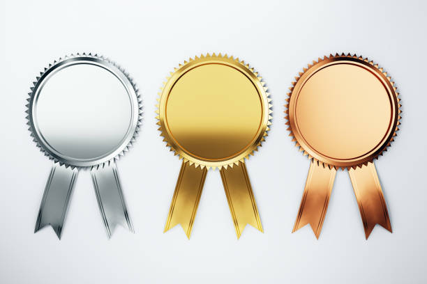 Gold, silver, and bronze medals on wooden table.