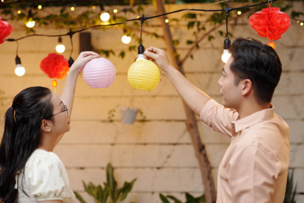 istock Couple Hanging Lanterns Together Outdoors 2178480464