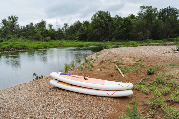 istock Tranquil Riverbank with Paddle Boards in a natural setting, surrounded by lush greenery and a peaceful atmosphere, offering a perfect outdoor adventure for nature lovers 2178480635