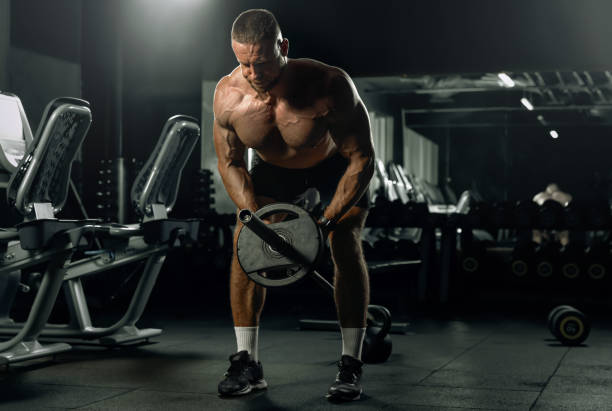 istock Muscular man having training with weights. Brutal strong athletic men pumping up muscles workout. Concept bodybuilder doing exercises in gym. 2178481796