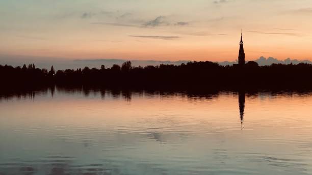 Zonsondergang aan een meer met een kerk