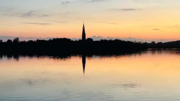 Zonsondergang aan een meer met een kerk