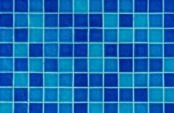 Blue glass mosaic tiles on white mortar. Texture background, real photo. Rough and scratched surface. Close-up photo suitable for background for graphic design.