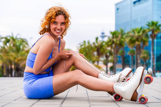 Beautiful red haired young woman with rollerskates having fun outdoors - Pretty female teenager girl with unique style riding on roller skates in the city
