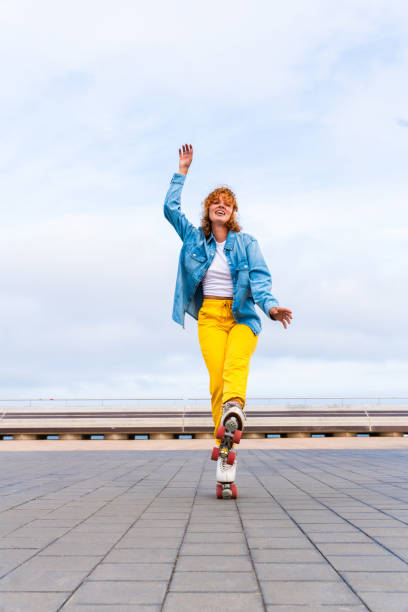 istock Beautiful red haired young woman with rollerskates having fun outdoors 2178488509
