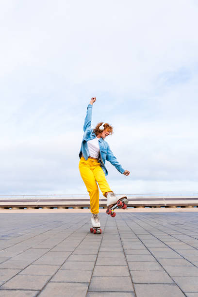 istock Beautiful red haired young woman with rollerskates having fun outdoors 2178488655