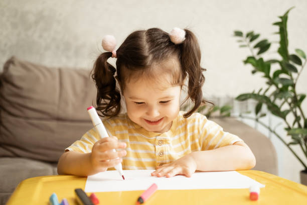istock Cute little girl drawing with marker at table indoors. 2178488747