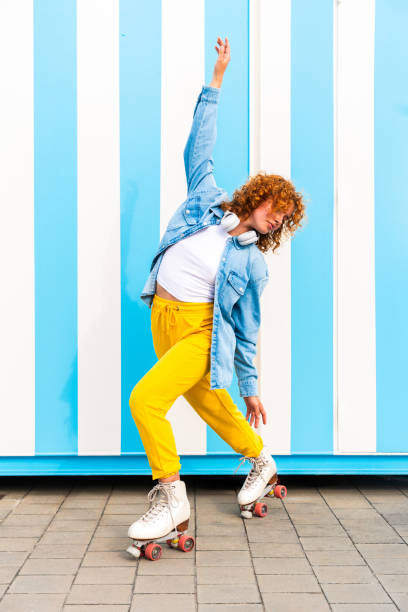 istock Beautiful red haired young woman with rollerskates having fun outdoors 2178488935