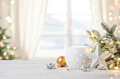Cozy Christmas table top with decorations and snow on blur abstract holiday background