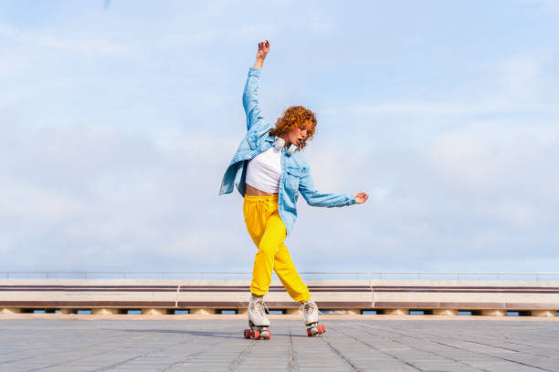 istock Beautiful red haired young woman with rollerskates having fun outdoors 2178489209