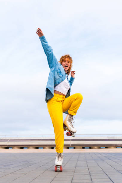 istock Beautiful red haired young woman with rollerskates having fun outdoors 2178489544