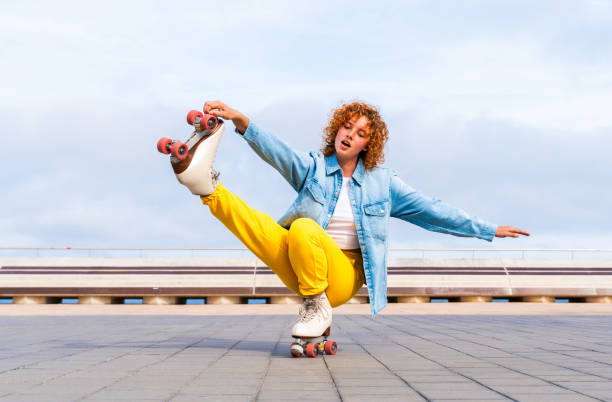 istock Beautiful red haired young woman with rollerskates having fun outdoors 2178489800