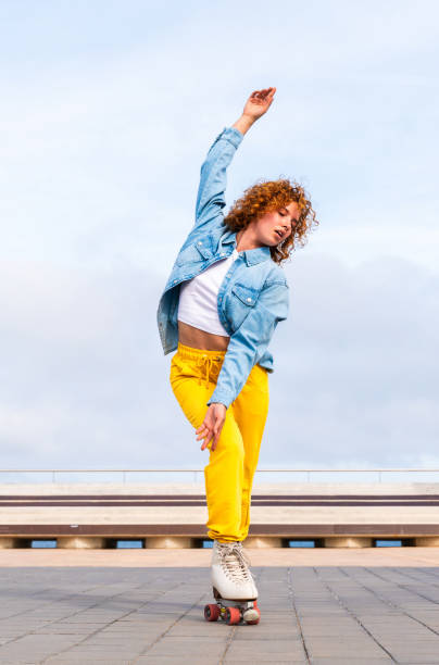 istock Beautiful red haired young woman with rollerskates having fun outdoors 2178489985