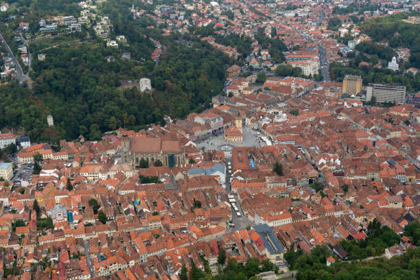Brasov, Romania, old city center aerial view with rooftops and turistic city square, medieval church and old architecture