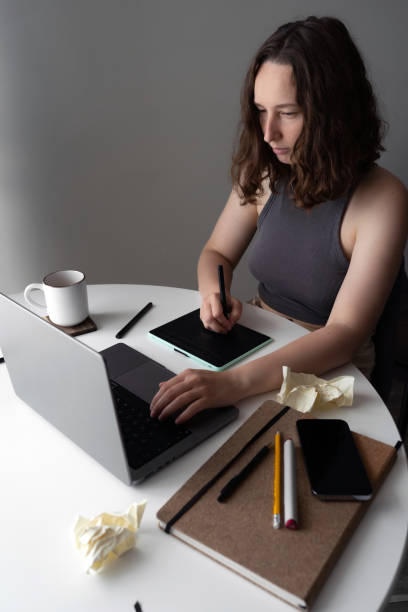 istock Focused woman working remotely on digital tablet and laptop at home office 2178493307