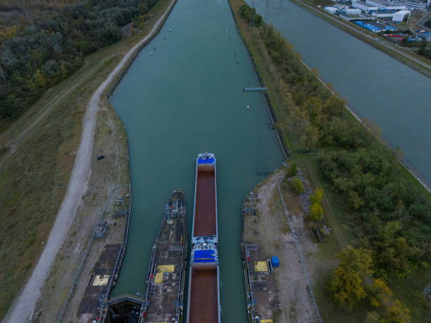Aerial image of a cargo vessel navigating through a lock system in a canal, highlighting waterway infrastructure and logistics for maritime transport.