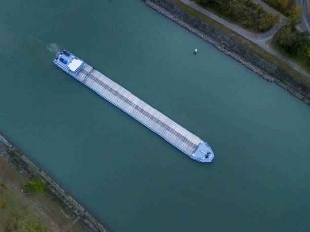 Aerial image of a large cargo vessel moving through a canal, showcasing maritime transport infrastructure and the scale of cargo transportation.