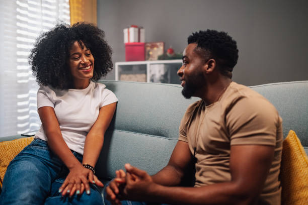istock Happy couple conversing joyfully on couch near tree. 2178497005