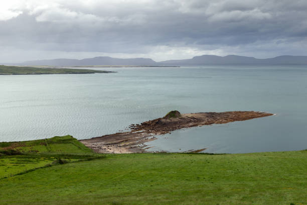 Mullaghmore Head in County Sligo, Ireland, with lush green fields and a rocky peninsula extending into the Atlantic Ocean under an overcast sky