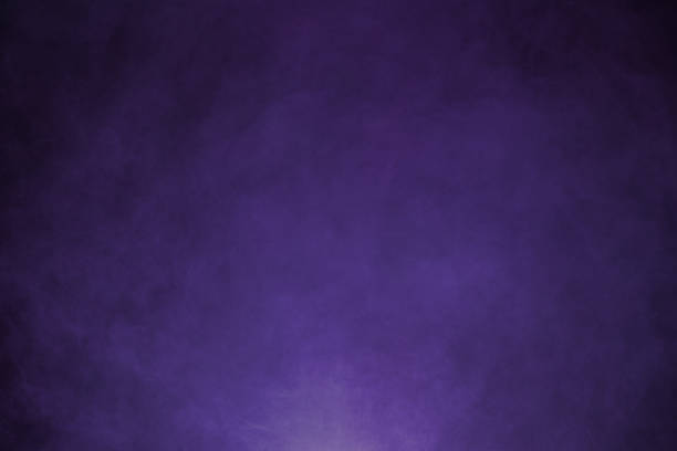 Thick, dark purple smoke swirls in an abstract pattern against a deep black backdrop. The rich, velvety hues of purple blend and twist, creating a sense of depth and movement as the smoke shifts and curls. The contrast between the deep purple and the black background enhances the mysterious and atmospheric quality of the scene, giving it a dramatic and otherworldly feel, perfect for an abstract and visually striking background.
