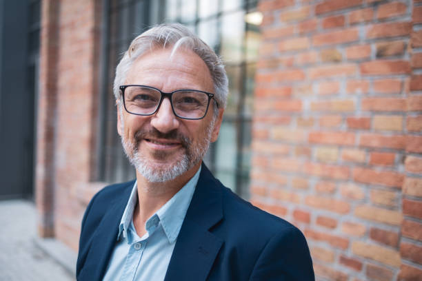 istock Confident senior businessman smiling outdoors at urban building 2178507052