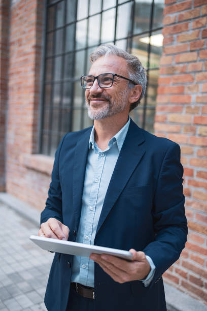 istock Confident businessman using a digital tablet outside an office building 2178507053