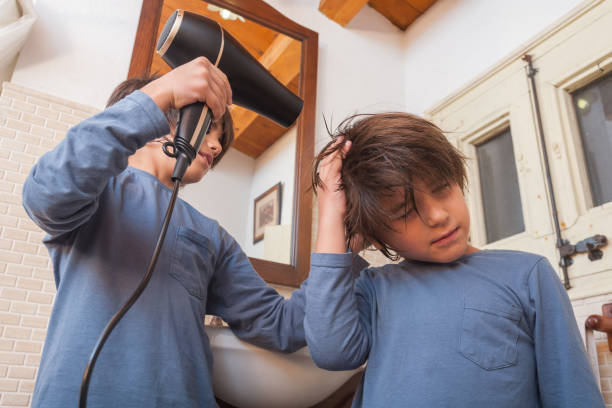 istock Two boys drying hair in bathroom with blow dryer 2178507432